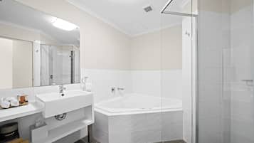 A modern bathroom with a white sink, mirror, and bathtub.