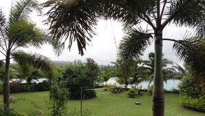 A well-maintained garden with a lawn, picnic tables, and a variety of plants and trees. - Jet Over Hotel (Salelologa)
