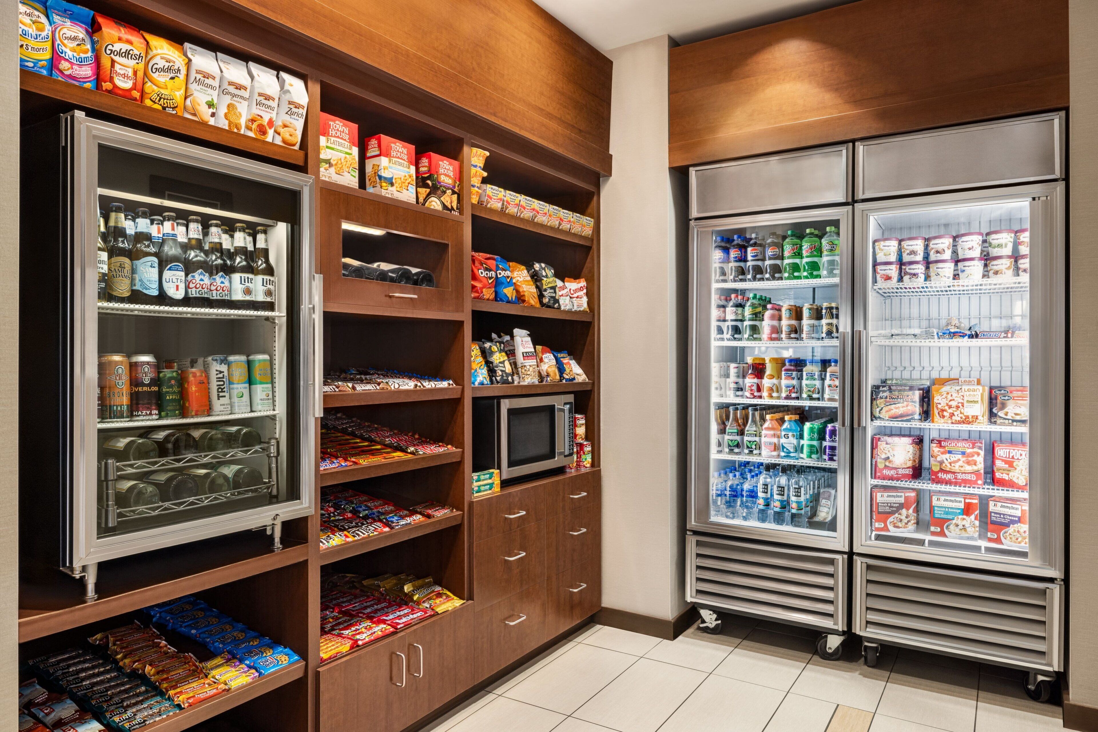 A well-stocked mini-fridge and pantry with snacks, drinks, and condiments.
