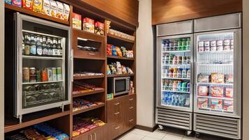 A well-stocked mini-fridge and pantry with snacks, drinks, and condiments.