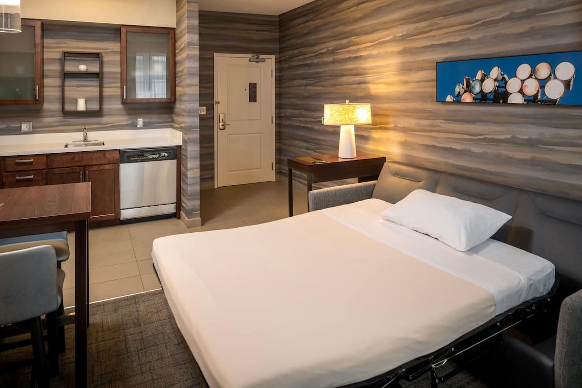 Luxe beddengoed, donzen dekbedden, een bureau, een laptopwerkplek
