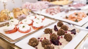 A buffet with various food items including croissants, cheese, and meat.