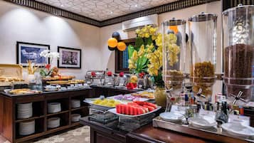 A buffet with various food items and a decorative centerpiece.