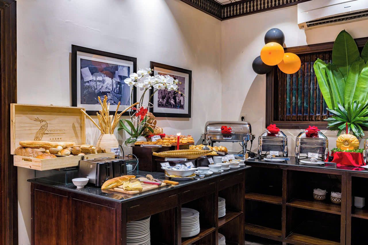 A buffet setup with various food items, a coffee station, and decorative elements like flowers and balloons.