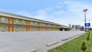 A motel with multiple rooms, a parking lot, and a Best Value Inn sign.