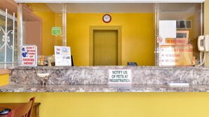 Ein Empfangsbereich mit Marmorzauber, einer Uhr und Schildern, die Rauchen verboten, Ausweis erforderlich und keine Rückerstattungen oder Schecks anzeigen.
