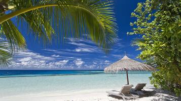 On the beach, white sand, sun loungers, beach towels
