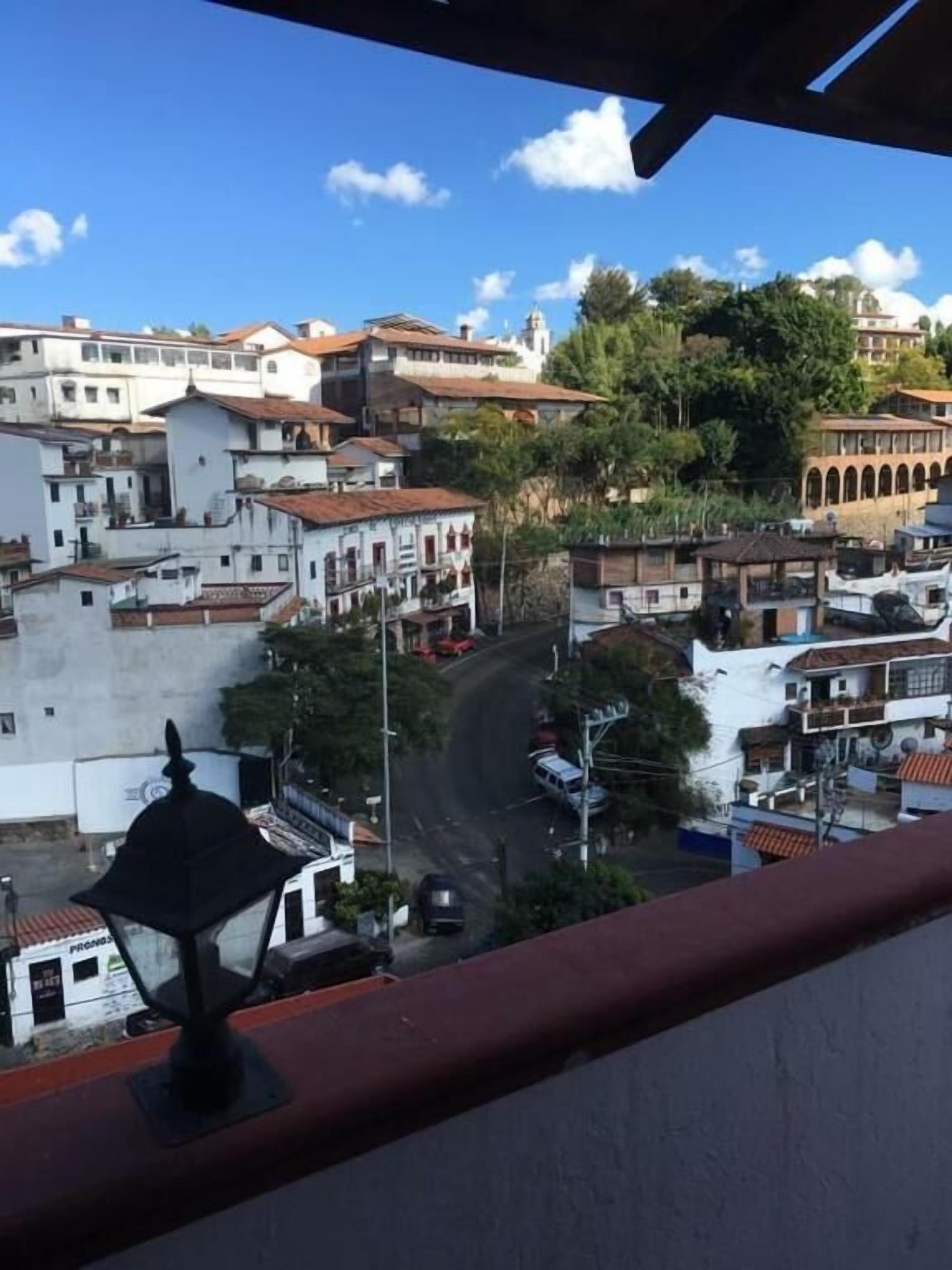 A view of a town with buildings, a winding road, and a clear sky.