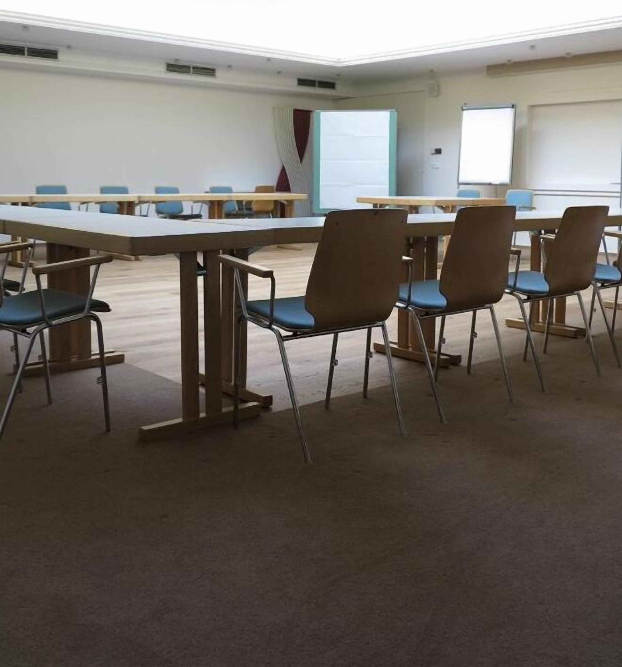 A conference room with a long table and several chairs.