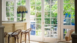 A conservatory with a glass door, wicker furniture, and a decorative lamp.