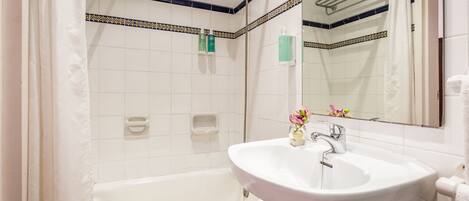 Baño con bañera blanca, lavamanos y ducha.