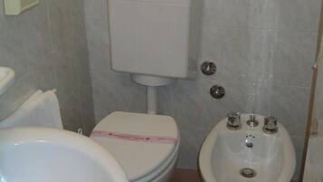 Ein Badezimmer mit Toilette, Bidet und Waschbecken.