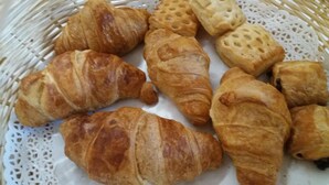 A basket containing various types of pastries, including croissants and puff pastries. - Moretti (Senigallia)