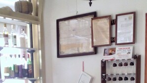 A reception area with a wooden counter, framed certificates on the wall, and a display of shoes. - Moretti (Senigallia)