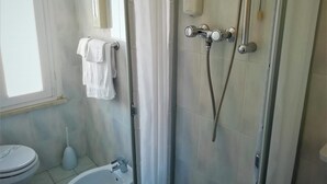 A bathroom with a shower, toilet, and sink.