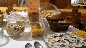 A buffet table with various food items including cereal flakes, yogurt, and bread. - Moretti (Senigallia)