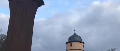 A statue on a pedestal with a tower in the background.