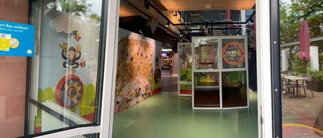 An indoor play area with climbing walls and a playhouse.