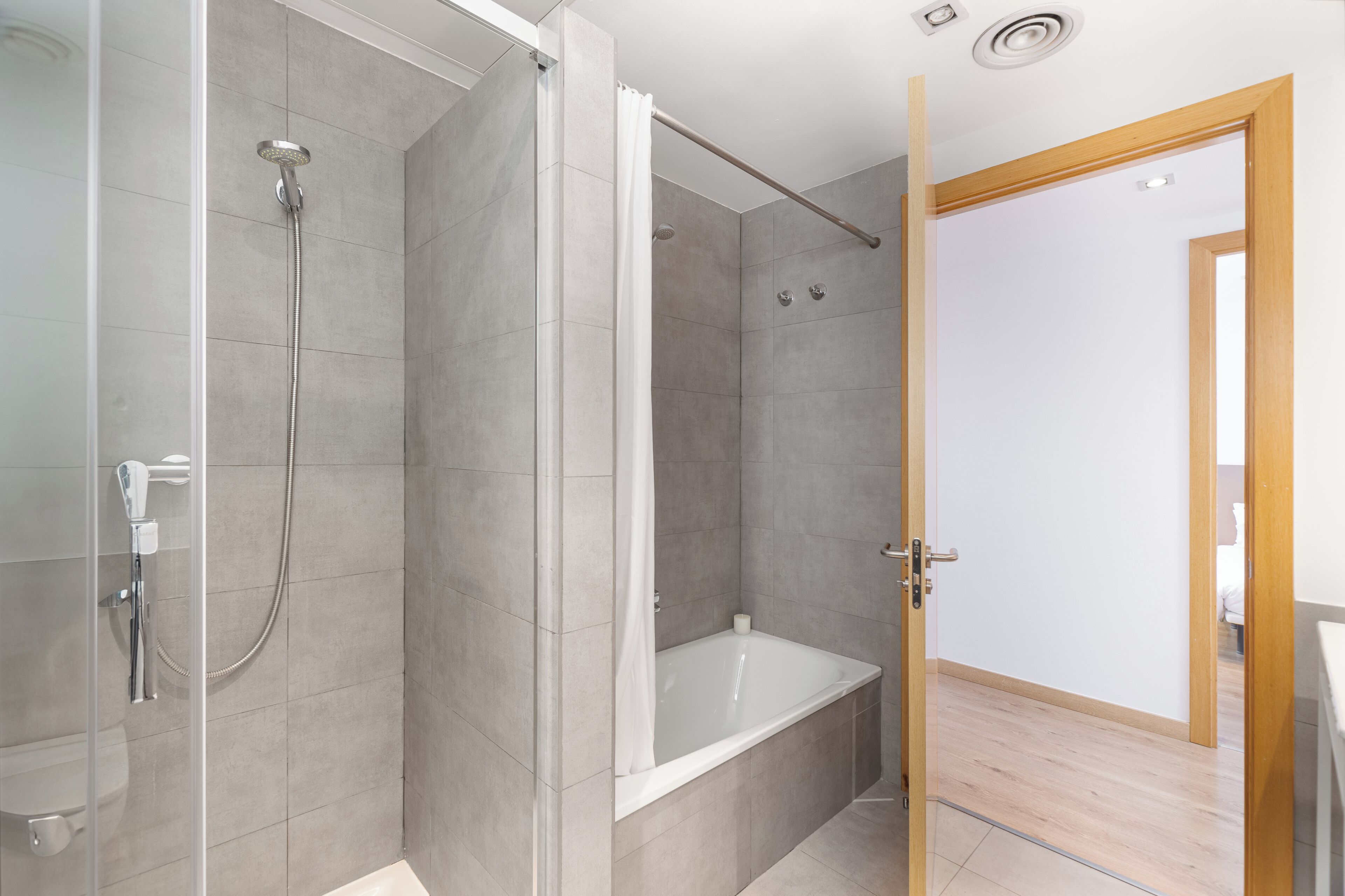 A modern bathroom with a shower, a bathtub, and a toilet.