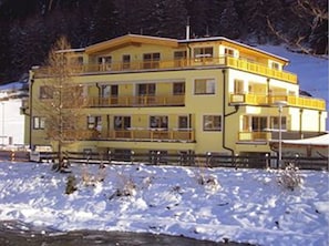A multi-story building with balconies, situated next to a body of water. - A CASA Residenz (Soelden)