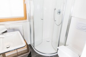 A modern bathroom with a glass-enclosed shower, a white sink, and a toilet. - A CASA Residenz (Soelden)
