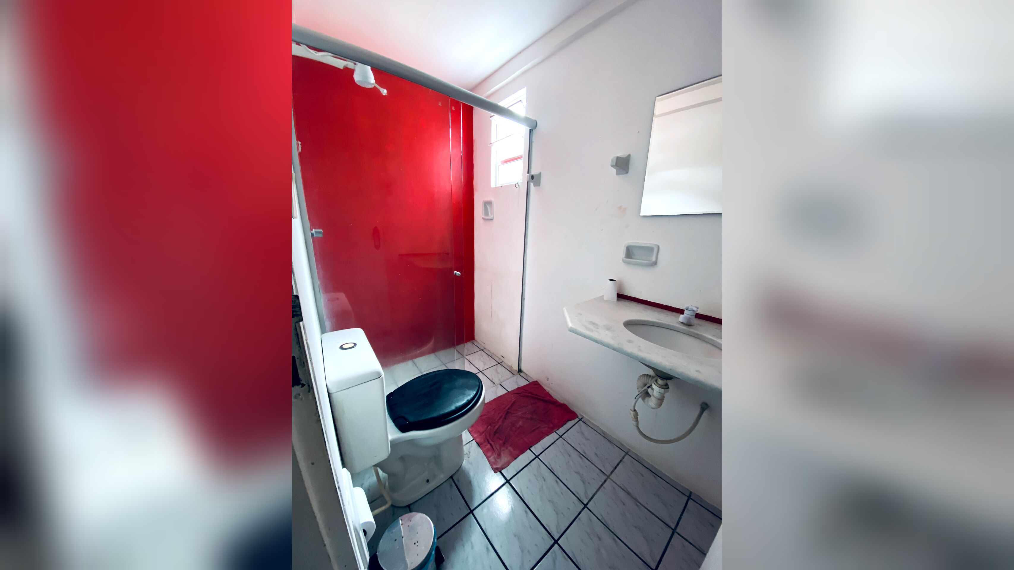 Een kleine badkamer met toilet, wastafel en douche.