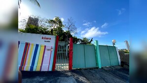 A hostel gate with a colorful striped sign and a red number 45. - Kuara Hostel Natal (Parnamirim)