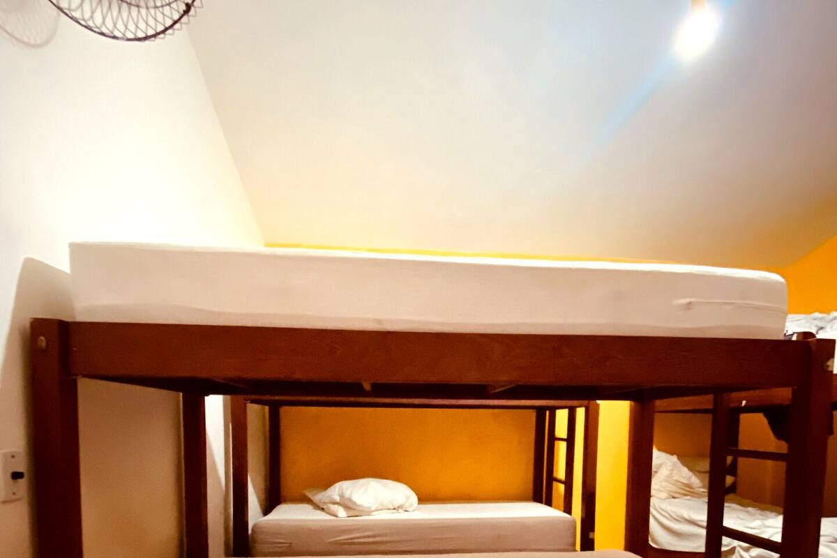 A bunk bed with a wooden frame, two beds, and a small storage drawer.