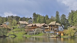 Un pueblo a orillas del lago con casas de madera tradicionales, un puente y barcos.