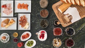 A variety of food items and condiments arranged on a dark surface. - Hotel Weihrerhof (Renon)