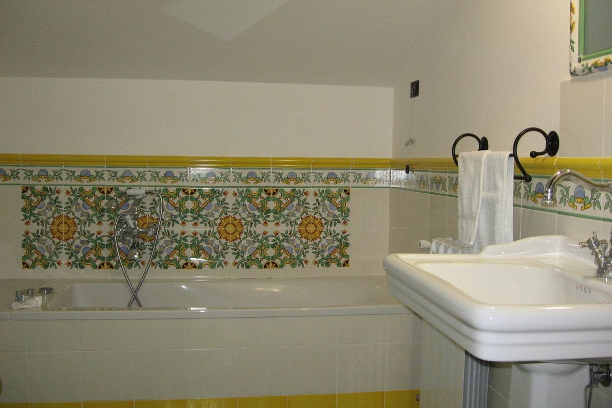 Un baño con bañera, lavamanos y espejo.