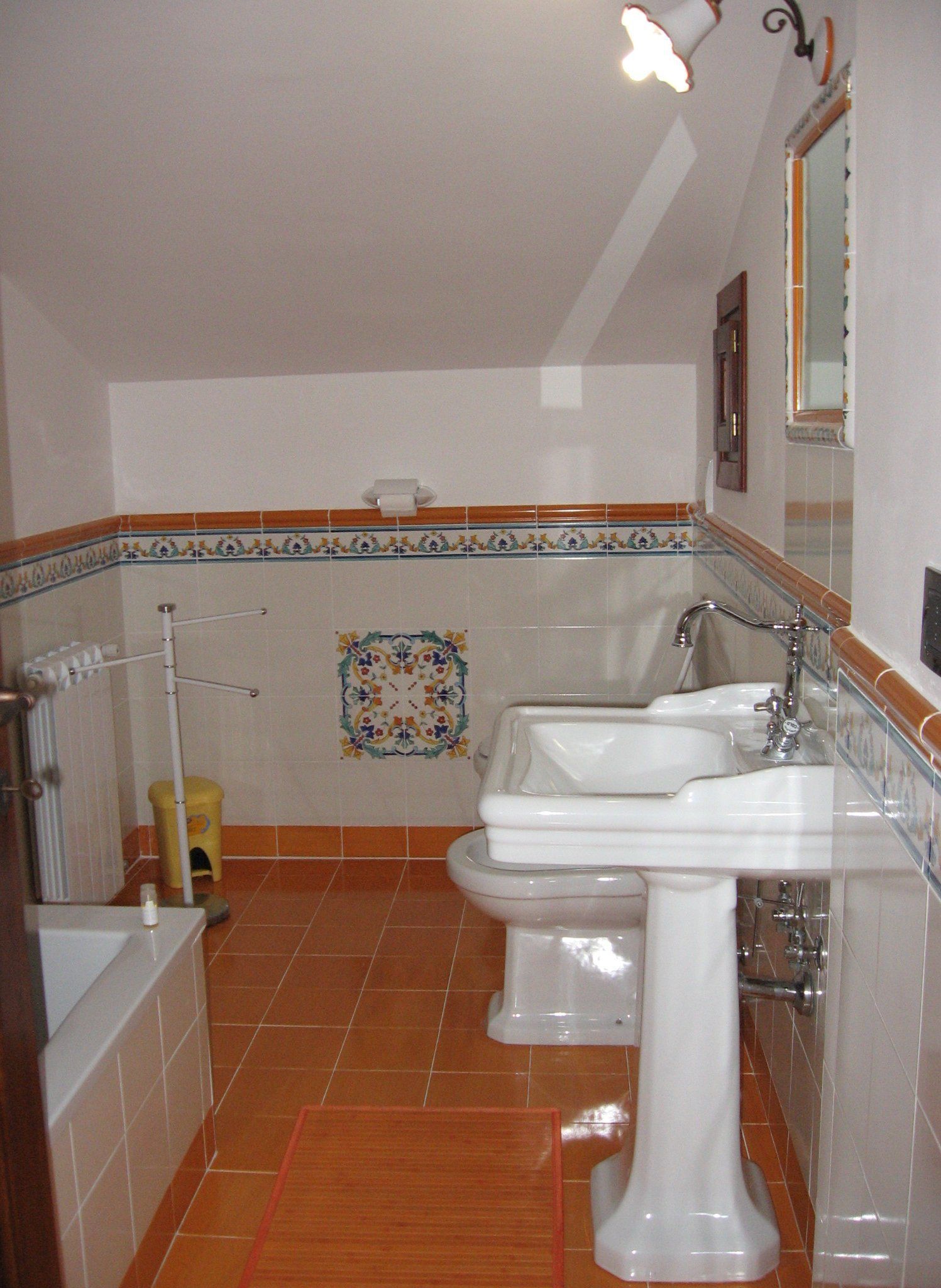 Un baño con dos lavamanos, un inodoro, una ducha y un espejo.