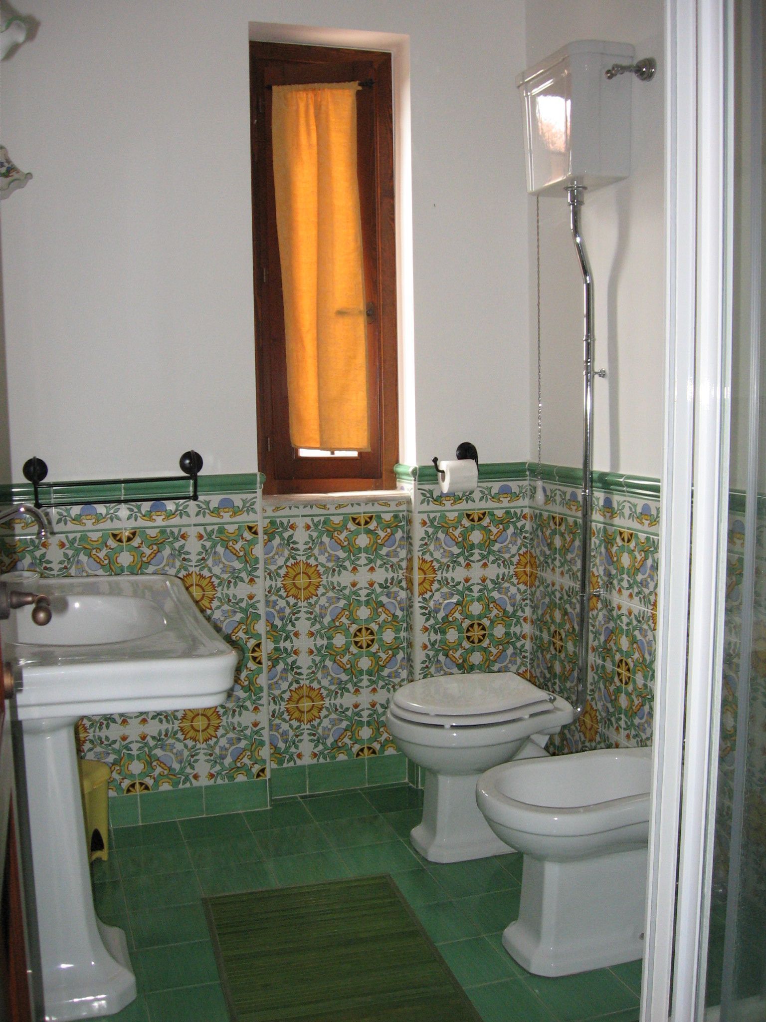 Un baño con lavamanos, inodoro y ducha.