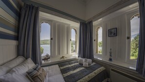 Une chambre avec un grand lit, une vue sur la mer et une décoration marine en forme d’étoile de mer.