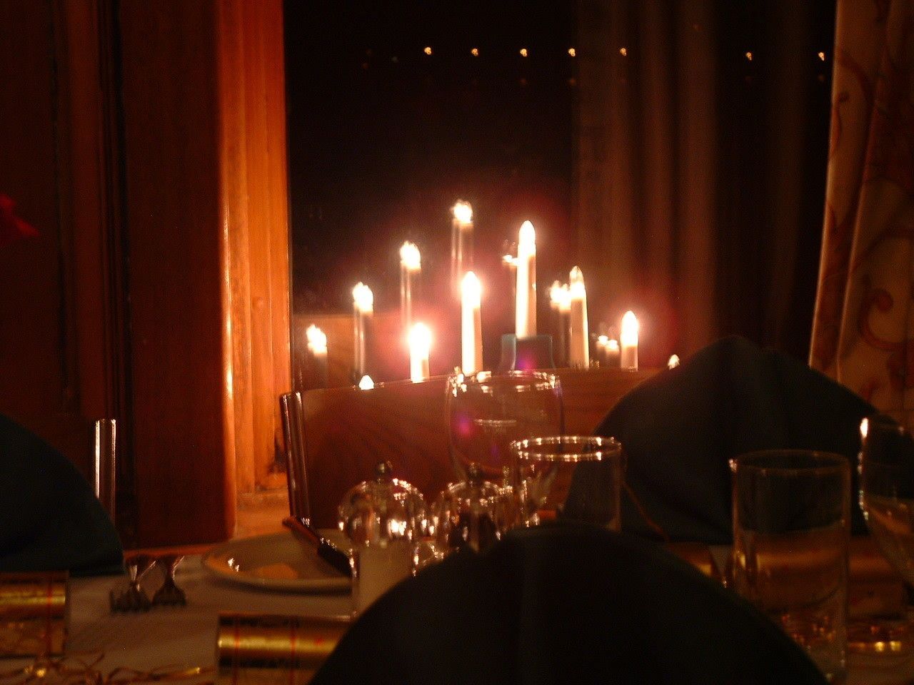 A dimly lit dining area with candles on the table, suggesting a romantic or intimate setting.