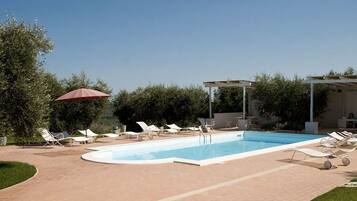 Piscine extérieure, parasols de plage, chaises longues
