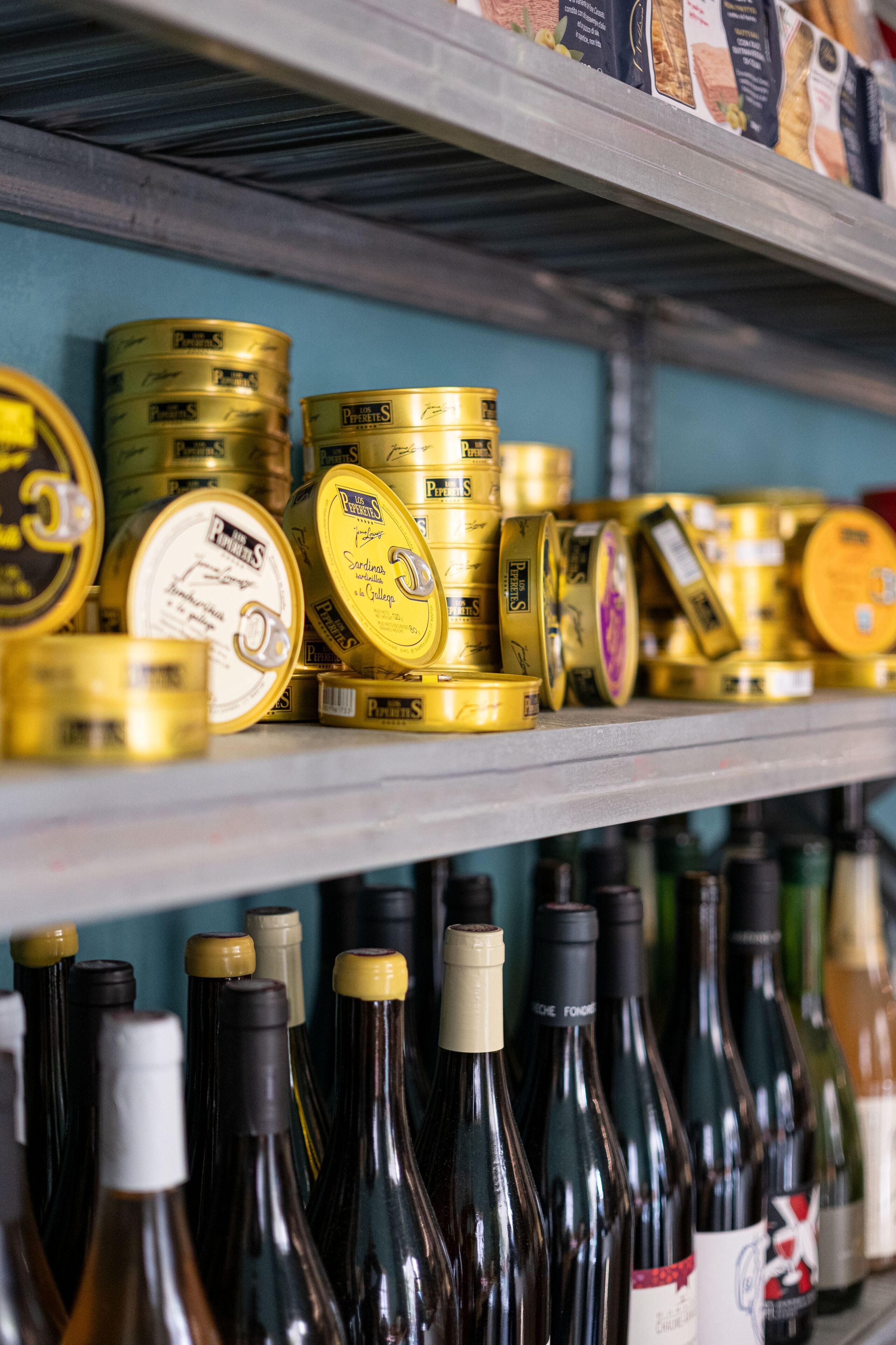 Regale voll mit Konservendosen und Weinflaschen.