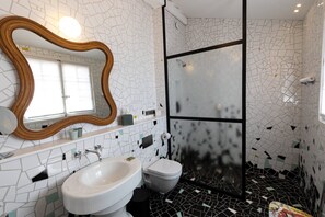 Ein Badezimmer mit Waschbecken, Toilette und Duschbereich.