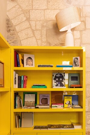 Ein gelbes Bücherregal mit verschiedenen Büchern und einer Lampe.