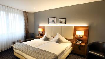 Relax in comfort with a large bed, two bedside tables, and a chair by the window.