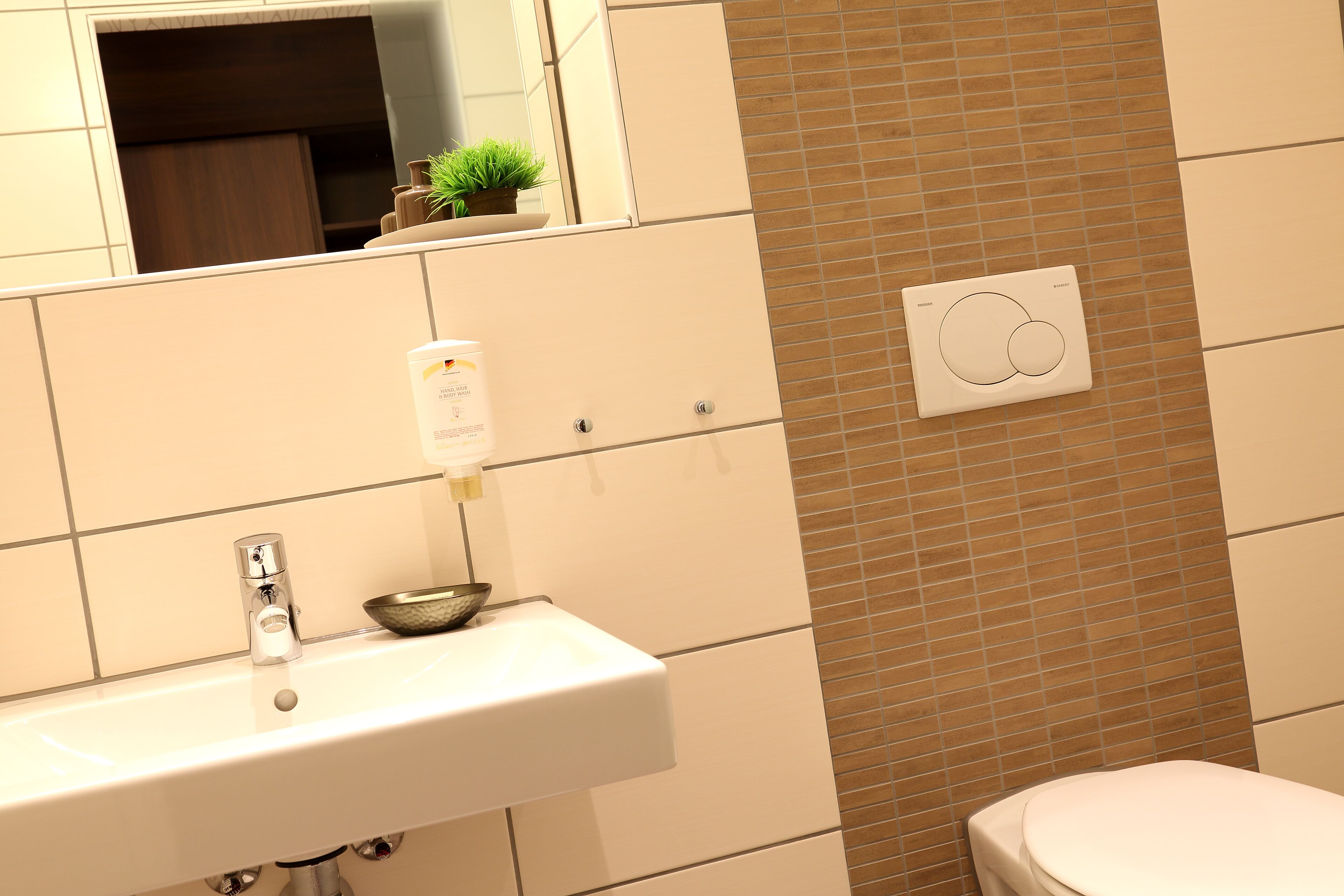Un baño con un lavamanos blanco, un espejo y un inodoro.