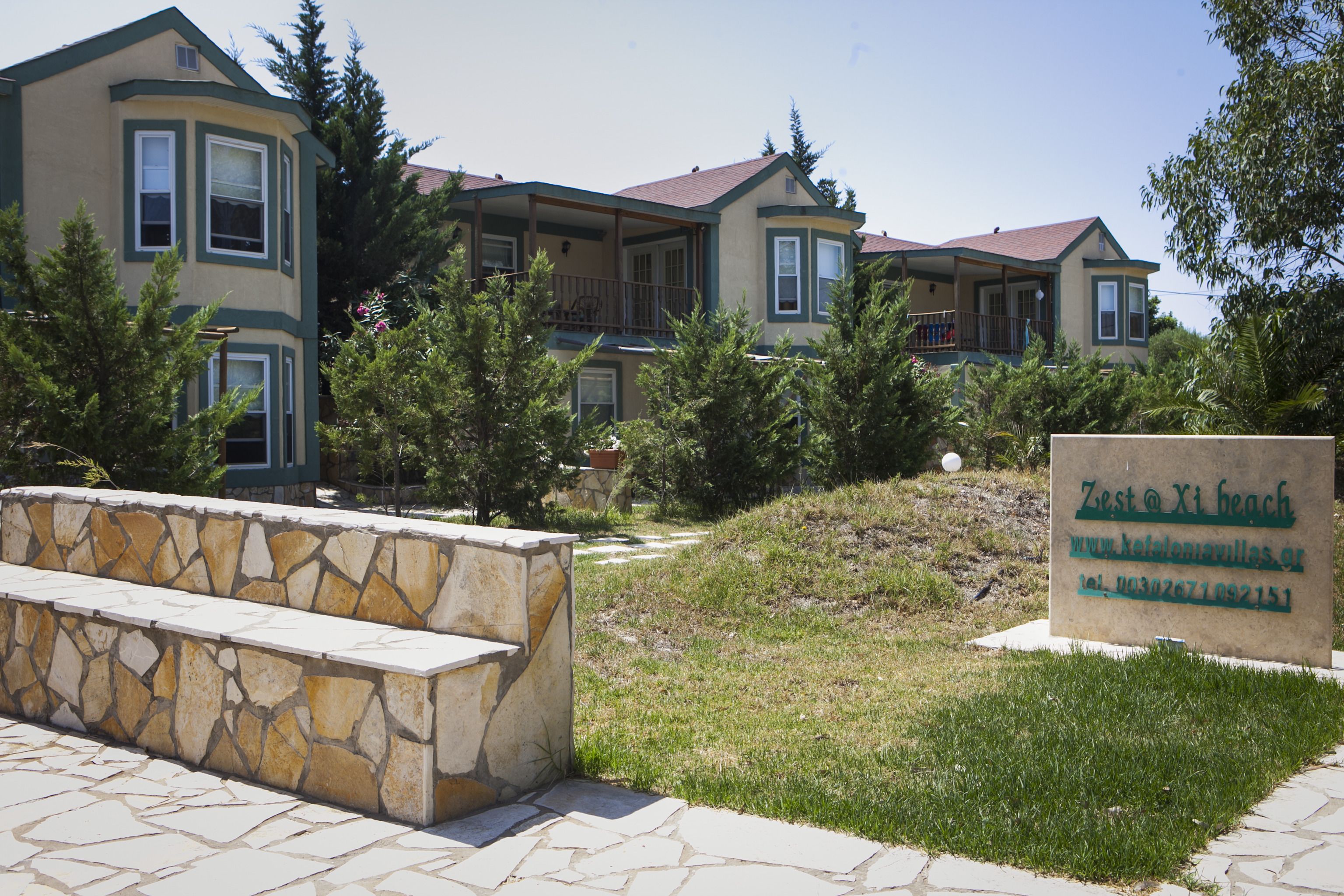 A multi-story building with a stone bench in the foreground.