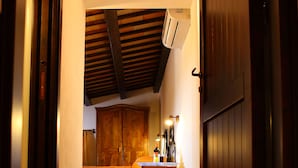 A narrow hallway leading to a room with a bed, wooden wardrobe, and a small table with bottles. - Bed & Breakfast Sabir (San Vito Lo Capo)