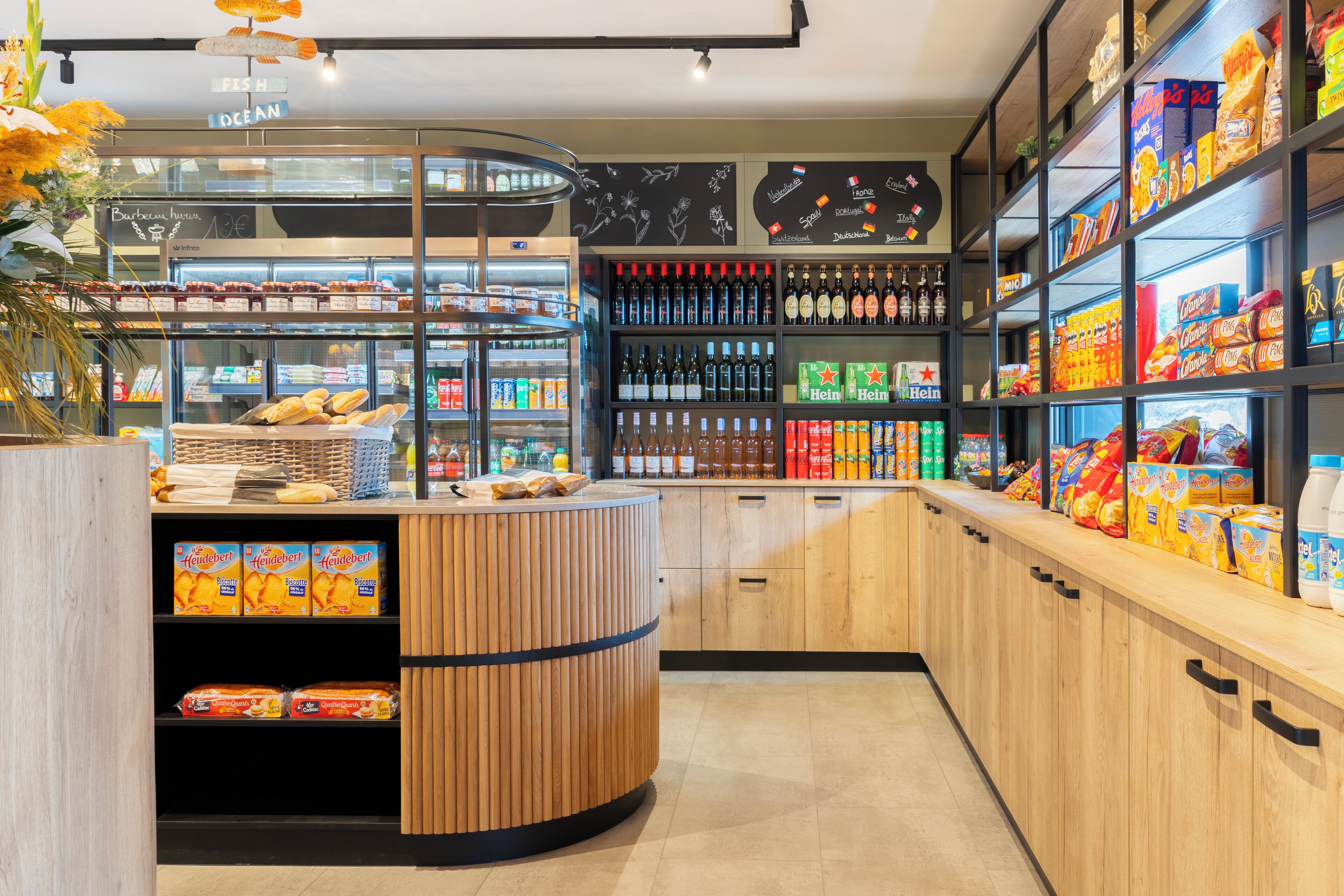 Un rayon boulangerie proposant du pain et des viennoiseries, des étagères remplies de boissons en bouteille et des en-cas emballés.