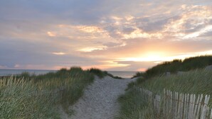 A sandy path flanked by grass leading to a beach with a wooden fence. - Dormio Resort Berck Sur Mer (Berck-sur-Mer)