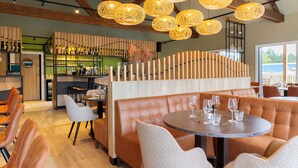 A restaurant with a bar area, seating arrangements, and a modern interior design. - Dormio Resort Berck Sur Mer (Berck-sur-Mer)