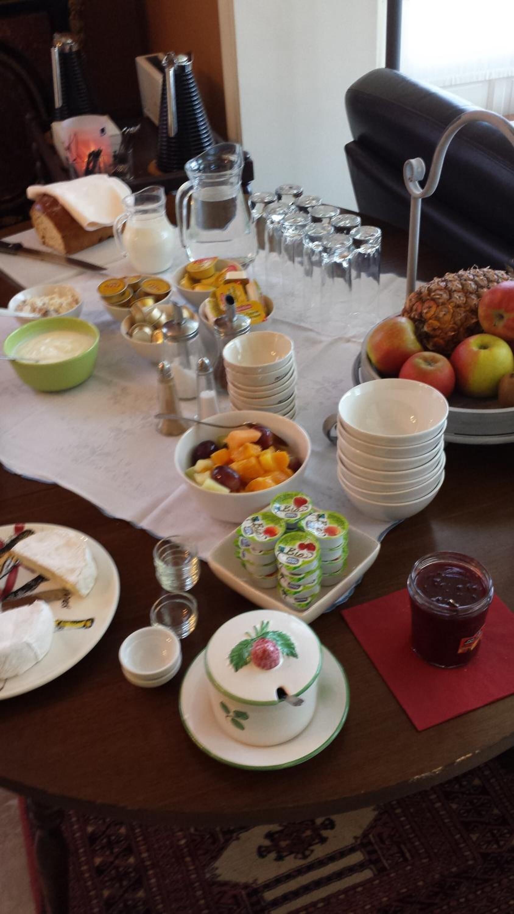 Ein Tisch, reichhaltig gedeckt mit verschiedenen Speisen, darunter Früchte, ein Kuchen und Beilagen.