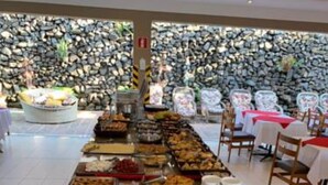 A buffet with various food items and beverages, including cakes, pastries, and drinks in pitchers. - Hotel Nascentes da Serra (Poços de Caldas)