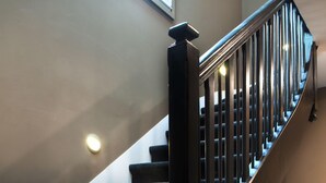 Una escalera con barandilla negra y peldaños alfombrados.