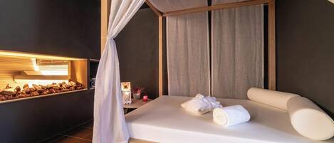 A modern hotel room with a bed, a nightstand, and a wall-mounted light.